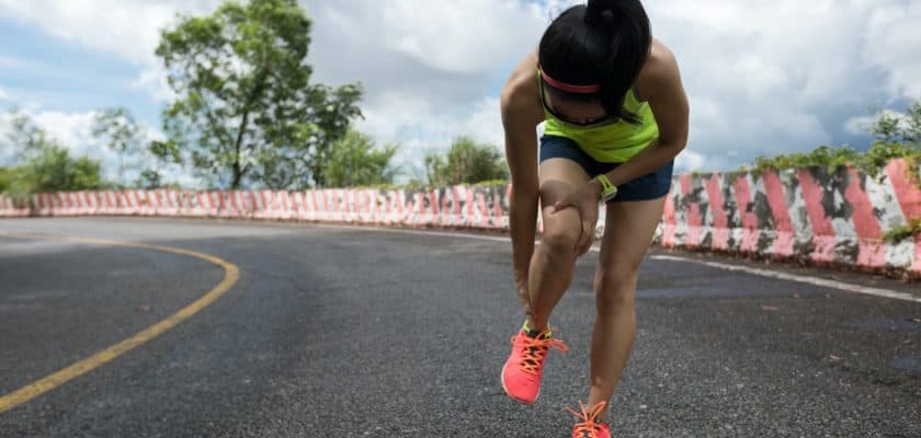 Woman runner suffering with pain on sports running knee injury
